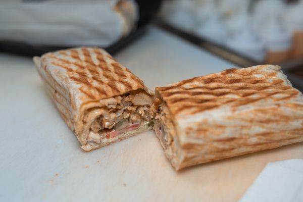 Spicy chicken shawarma being sliced fresh off the spit